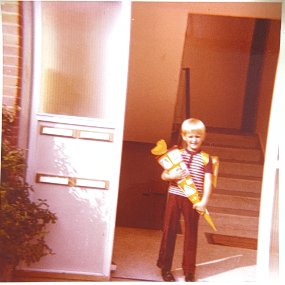 Einschulung in Schleswig, ca. 1972 — mit sechs Jahren, Schultüte rot-gelb, gestreiftes Polo.